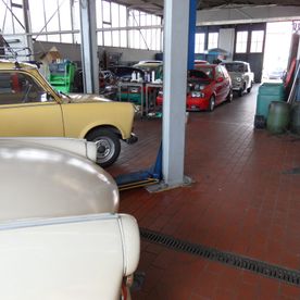 Gelber Oldtimer in einer Werkstatt